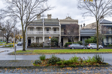 Fototapeta premium Historic Victorian-era terrace houses along a residential street in East Melbourne, Australia, featuring ornate wrought-iron balconies, traditional façades on a cold winter day. Heritage housing