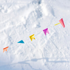 Colorful flags strung across a snowy landscape for festive decoration and celebration
