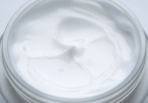 Close up swirl texture of white cosmetic cream in a container