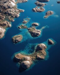 Fototapeta premium Aerial View of Serene Blue Waters and Rocky Islands Surrounded by Lush Greenery in a Remote Coastal Landscape