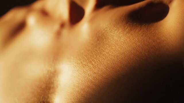 Close up of human skin texture with subtle highlights and shadows showing pores and natural contours in warm golden light
