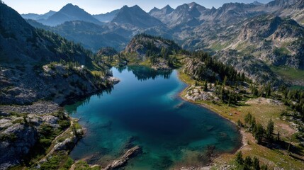 Majestic aerial view of serene mountain lake with clear blue waters surrounded by lush green forests and rocky terrain