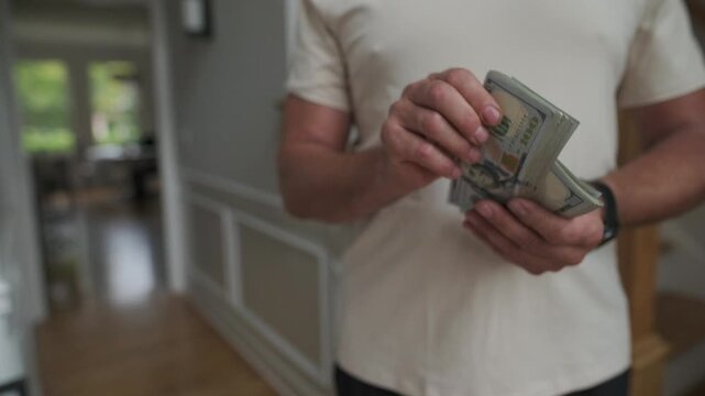 homeowner pays contractor, homeowner from caucasus offering cash as payment in corridor, individual of caucasian ethnicity financially compensating service worker in hallway with cash notes