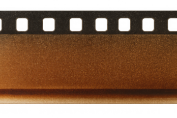 Vintage distressed film strip with sprocket holes and grain on a transparent background, depicting old movie production