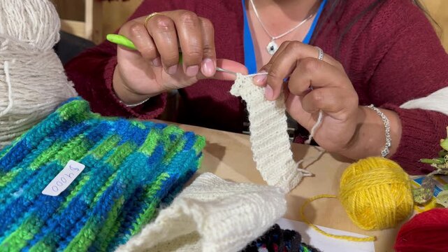 Manos de una mujer mapuche tejiendo piezas tradicionales de la cultura en el sur de Chile.
