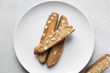 Overhead view of almond biscotti on a white plate, top view of almond cantucci on white background