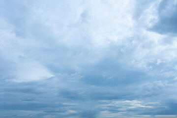Expansive overcast sky filled with layers of dense moody light blue and grey stratocumulus clouds