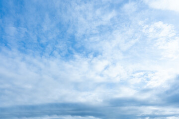 Blue sky with varied white and gray clouds layered across the entire frame