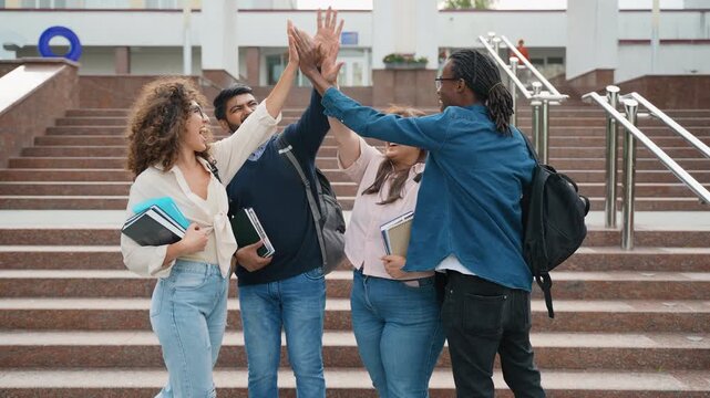 Diverse university students celebrating success with group high five