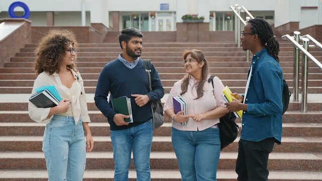 Diverse group of university students high fiving on campus steps
