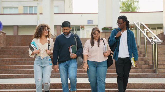 Group of diverse university students walking together downstairs