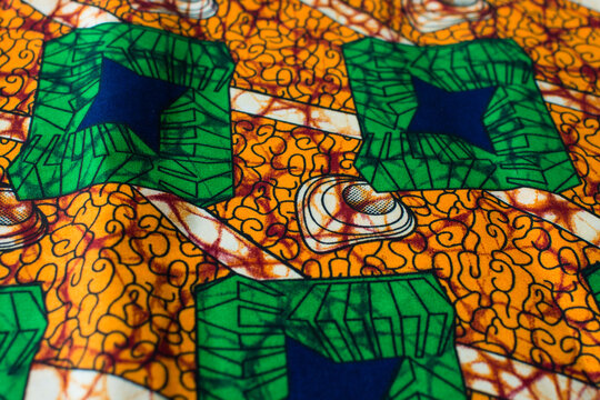 top view of orange ankara fabric, flatlay of nigerian wax cloth with designs, spread out orange ankara material