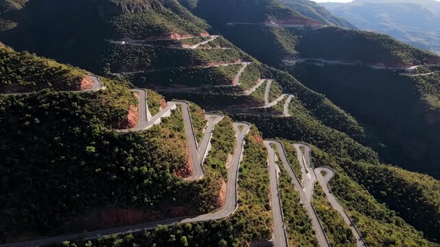 Winding mountain road on a steep green hillside landscape