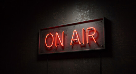 A bright red neon 'ON AIR' sign glows on a dark, textured wall. It symbolizes a live broadcast or recording