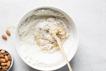 overhead view of almond biscotti dough being mixed in a white bowl, flatlay of biscotti cookie dough or twice baked cookie dough