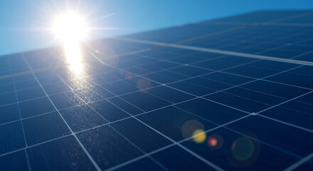 Close-up view of solar panel cells reflecting sunlight against a blue sky