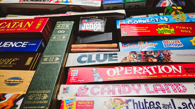 Looking up at a collection of classic board games for many interests. Titles include Catan, Go, Operation, Scrabble, Risk, Clue, Connect Four, and more. For Editorial Use Only.