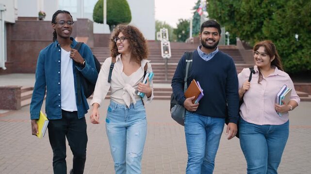 Diverse group of university students walking and talking on campus
