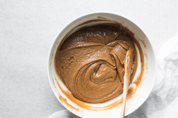 overhead view of brown sugar cookie dough being mixed in a white bowl, process of making fresh sugar cookies