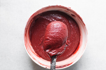 Overhead view of red velvet brownie batter being mixed in a white bowl, process of making red velvet brownies