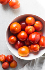Overhead view of tomatoes on a white marble countertop, top view of tomatoes on white chopping board