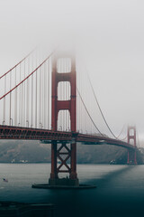 Golden Gate Bridge partially hidden in thick coastal fog.