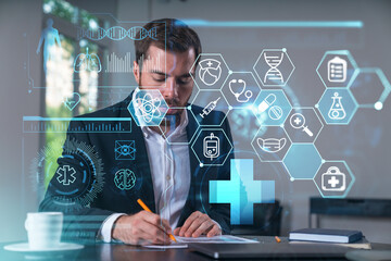 Calm businessman in formal wear signing contract at office workplace with coffee cup, laptop and notebook. Concept of successful deal, agreement, partnership, documents. Medical healthcare icons.