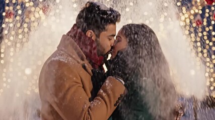 Romantic couple embracing in snowy winter wonderland with beautiful holiday lights creating intimate memories together