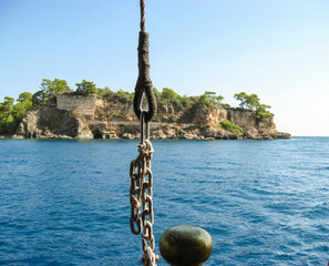 Rocky island and sea cliffs with chain from boat view horizontal