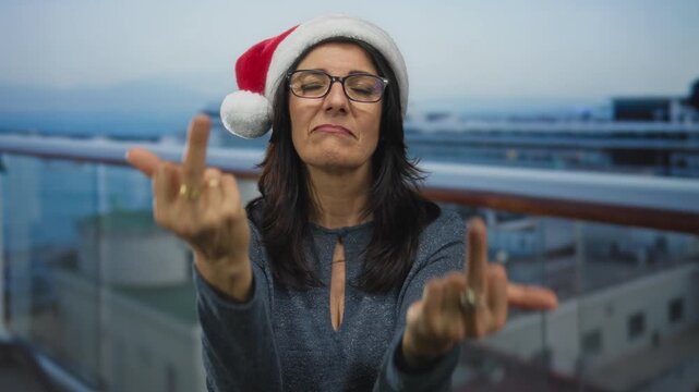 Hispanic woman shows both middle fingers in front of a ship railing on building deck; anger defiance.