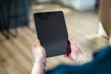 A man in his 30s interacts with a tablet at home, showcasing modern technology use.
