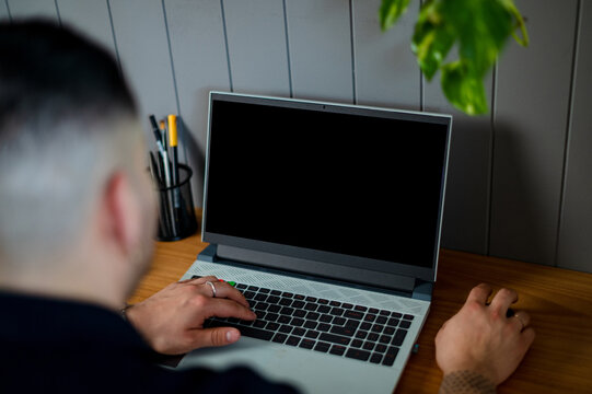 upper vision crop shot of a man working at his laptop in his home office