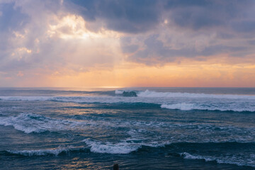thick clouds covering the warm morning sun and the sea waters that are turbulent due to the wind