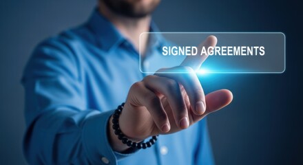 Businessman touching glowing digital interface button labeled signed agreements, for contract finalization, secure electronic documentation, successful business closure