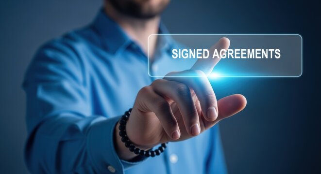Businessman touching glowing digital interface button labeled signed agreements, for contract finalization, secure electronic documentation, successful business closure