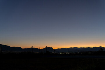 Obraz premium 山の向こうに見える夕焼け