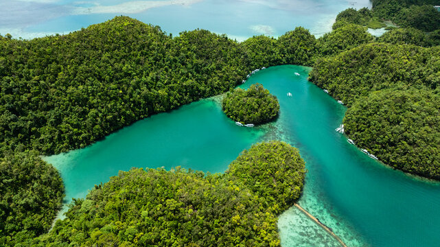 Aerial view of lagoon with small forest islands and boats floating on calm water. Siargao, Philippines. Sugba Blue Lagoon. - Powered by Adobe