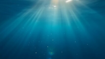 Sunlight streams into the mesmerizing depths of the ocean, shimmering and dancing underwater in a vibrant display of aquatic beauty, perfect for ocean life visuals