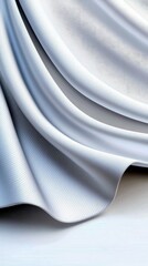 A close-up view of flowing white fabric with visible texture, creating soft curves and shadows.