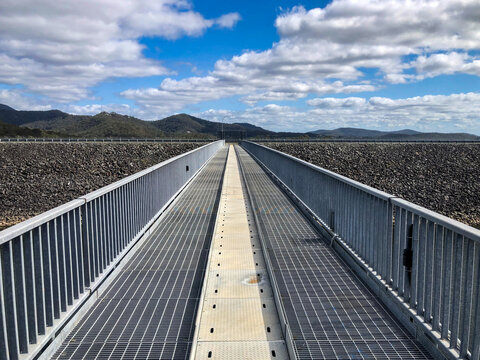 Elevated metal walkway and dam wall.