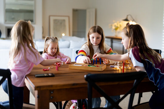Young girls playing colourful rectangular blocks on the table