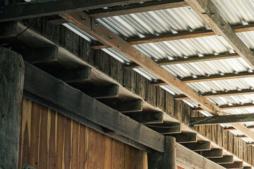 The foreground features smooth, warm-toned vertical wooden planks and stepped timber eaves,...