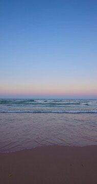 Morning over the beach shore and calm sea waves vertical seascape beautiful view