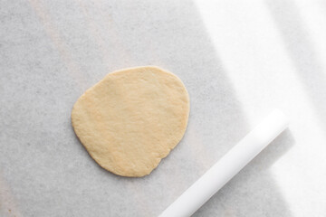 Coco bread dough on a parchment lined baking tray, process of making jamaican coco bread