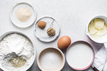 overhead view of mise en place for hot cross buns dough, ingredients for making hot cross buns on a marble countertop