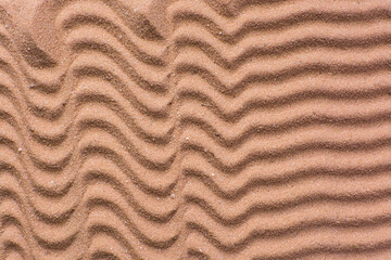 close up view of textured brown sand background, beautiful sand texture, overhead view of zen pattern drawn in brown sand, Top view of fine grain texture