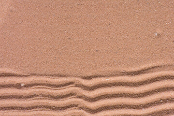 close up view of textured brown sand background, beautiful sand texture, overhead view of zen pattern drawn in brown sand, Top view of fine grain texture