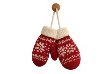 Pair of red knitted wool mittens with white snowflake pattern hanging on a wooden hook, winter holiday clothing accessory