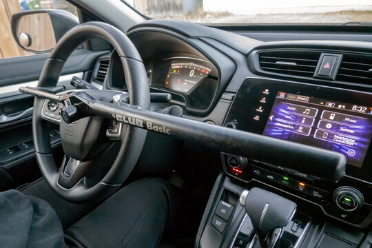Calgary, Alberta, Canada. Nov 16, 2025. A "The Club Basic" anti-theft device is securely locked onto the steering wheel of a modern car, visible from the driver's perspective.