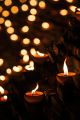 clay oil lamps lit along the brick walls at Jaeng Hua Rin and around the Chiang mai moat, their warm flames glowing softly at night during the Yi Peng festival